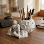 CONQR astronaut moon pen stand holding pens and pencils on a walnut office desk