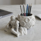 Close-up of CONQR astronaut pen stand showing speckled marble grey finish and moon craters